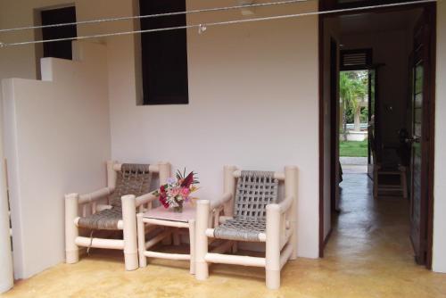 two chairs and a table with a vase of flowers at Villa La Plantacion in Las Galeras