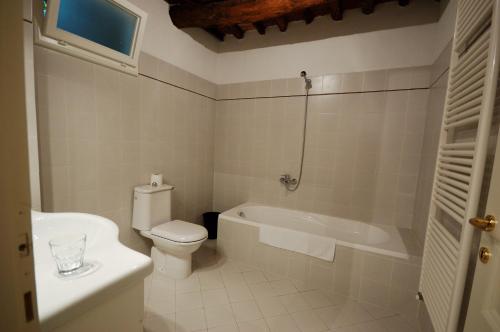 a bathroom with a toilet and a tub and a sink at Fattoria di Fubbiano in Collodi
