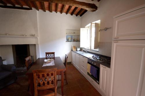 a kitchen with a table and a dining room at Fattoria di Fubbiano in Collodi