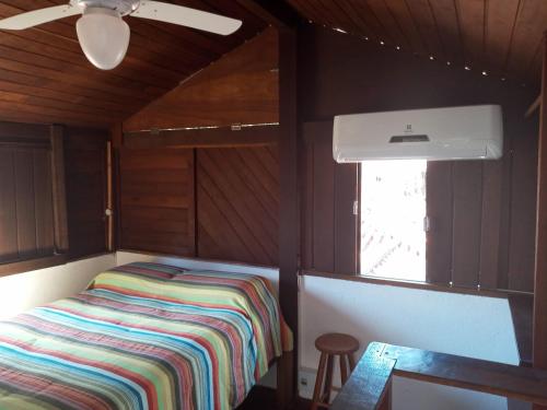 a small room with a bed in a cabin at Pousada Cachoeira in Abraão