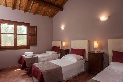 a bedroom with two beds and a window at Casa vacanza Asfodeli in Teulada