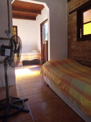 a bedroom with a bed and a fan in a room at Pousada Cachoeira in Abraão