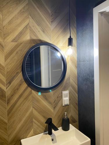 W łazience znajduje się lustro i umywalka. w obiekcie Apartament 87 w Szczecinie