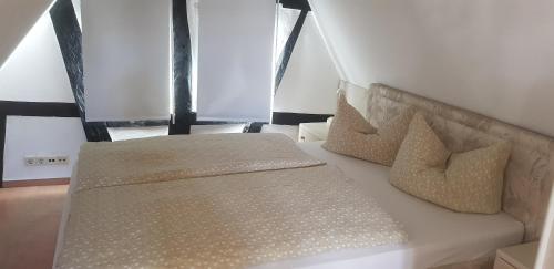 a bed with two pillows on it in a room at Penthouse im historischen Fachwerkhaus mit grosser Dachterrasse an zentralster Lage in Boppard