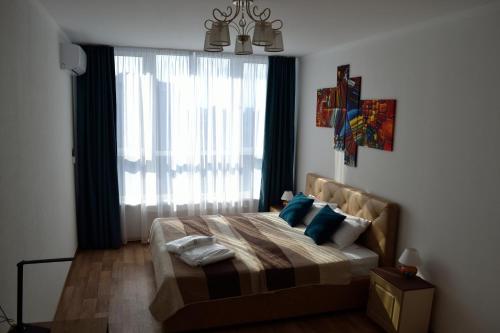 a bedroom with a bed with a large window at In the sky apartment Kyiv in Kyiv