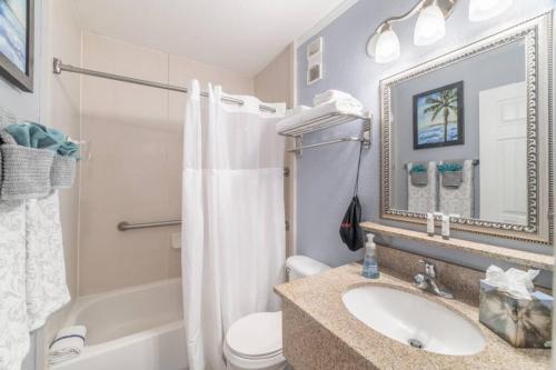 a bathroom with a sink and a toilet and a mirror at 311-Mermaids condo in Tampa