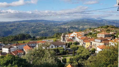 a town on a hill with mountains in the background at Casa da Zéfinha, em Cinfães, no Douro in Cinfães