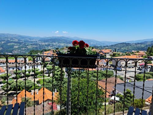 a vase with flowers sitting on top of a balcony at Casa da Zéfinha, em Cinfães, no Douro in Cinfães