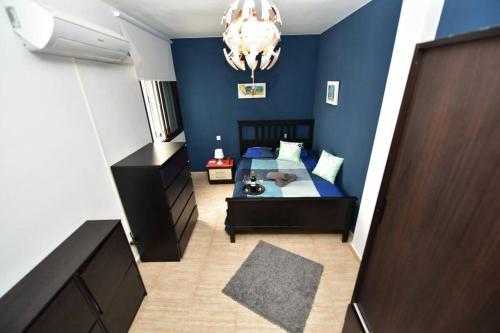 Dormitorio azul con cama y lámpara de araña en Casa Flores, en Arrecife