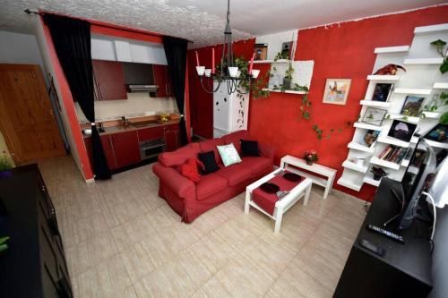 - un salon avec un canapé rouge et une table dans l'établissement Casa Flores, à Arrecife