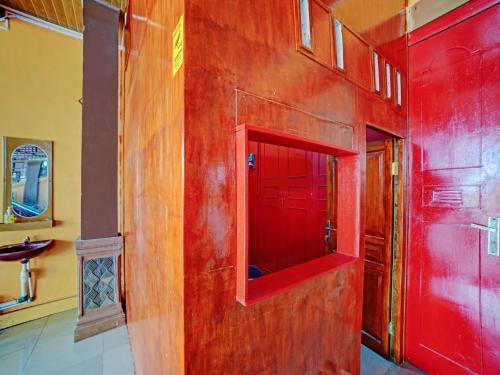 a bathroom with red walls and a red door at OYO 90387 Sepakat Guest House in Medan