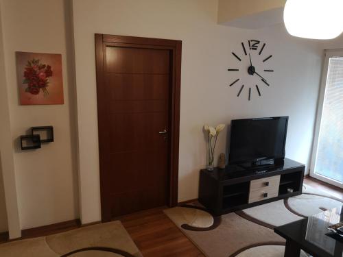 a room with a door and a clock on the wall at Hello Apartment in Skopje