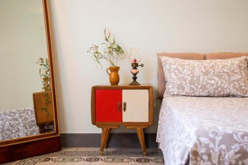 a bed with a red cabinet next to a mirror at Casa Terracotta in Matera