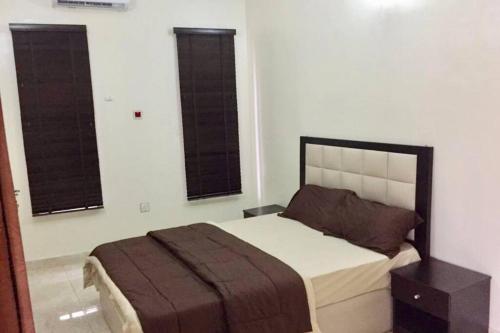 a bedroom with a bed and two windows at DELIGHTFUL ! 3 BEDROOM TERRACE DUPLEX EN-SUITE ORCHID RD LEKKI AIRCON WiFi in Lagos