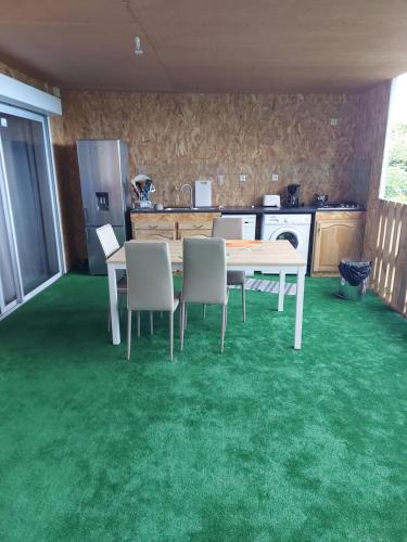 a kitchen with a table and chairs on a green carpet at GRAND T3 - BELLEPIERRE ST DENIS in Le Brûlé