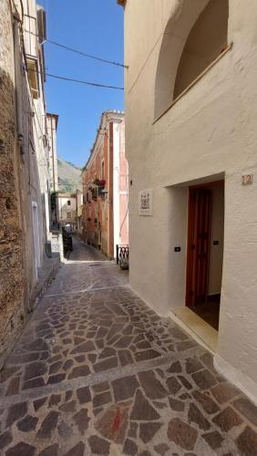 um beco vazio com um edifício e uma porta em B&B Biancamano em Maierà