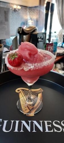 a drink in a martini glass with a strawberry in it at Fennessy's Hotel in Clonmel