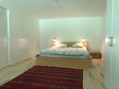 a bedroom with a bed with two lamps and a rug at Villa 4 rooms in Hillerød