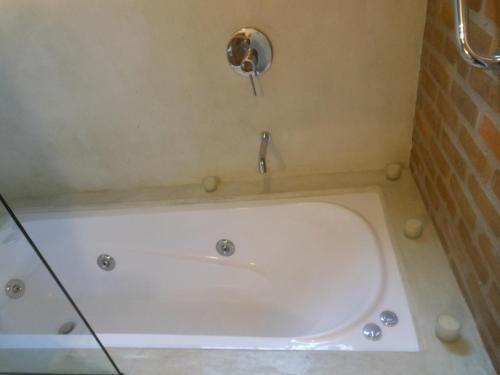 a bath tub in a bathroom with a faucet at Il Tano Suites in Punta Del Diablo