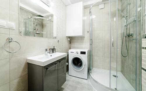 een badkamer met een wasmachine en een wastafel bij Apartament przy stoku z ogrodem i tarasem - Pod Karpatką Residence Karpacz in Karpacz