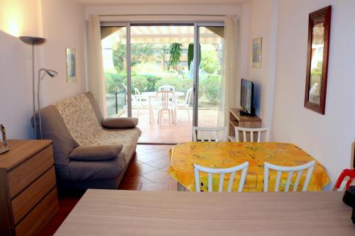 a living room with a table and a couch at T2 Terrasse, Bormes Les Mimosas La Faviere, 5 mn à pieds des plages et commerces in Bormes-les-Mimosas