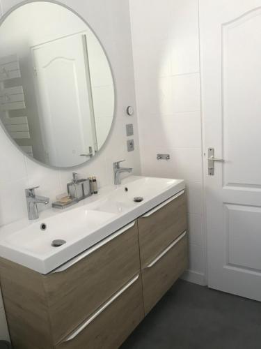 y baño con lavabo blanco y espejo. en Zoralin en Concarneau
