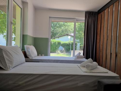 - une chambre avec 2 lits et une grande fenêtre dans l'établissement Fuk-tak's bungalow, à Dojran