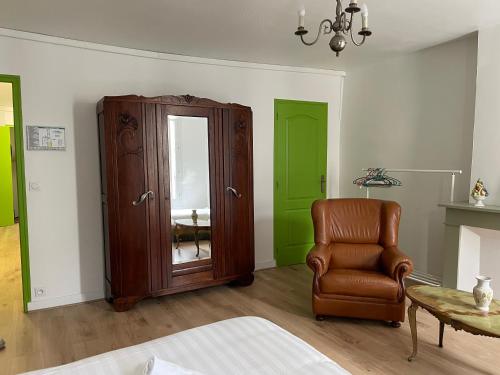 uma sala de estar com uma cadeira e um armário em Gîtes des châteaux : gîte C em Selles-sur-Cher