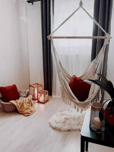 a hammock hanging in a room with a window at Długopole Dolne Apartament in Długopole-Zdrój
