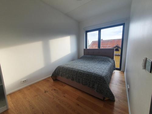 1 dormitorio con cama y ventana grande en Cozy apartment in the heart of Pärnu en Pärnu