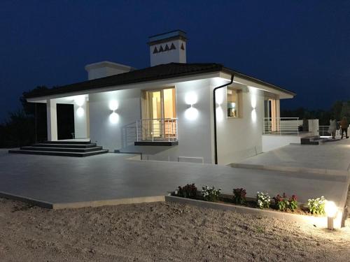 a small white house with a clock tower on top at Tenuta Bardi in Villa Baldassarri