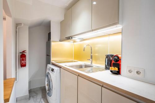 eine Küche mit einer Spüle und einer Waschmaschine in der Unterkunft HolidaysInParis - Bourg Tibourg in Paris