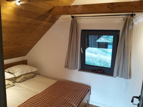 a bedroom with a bed and a window at WIATR W KOMINIE dostęp do jeziora UBLIK in Konopki Wielkie