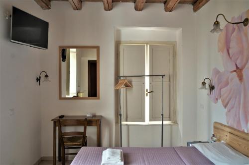 a bedroom with a bed and a mirror and a desk at Hotel Baldo in Ferraro di Monte Baldo