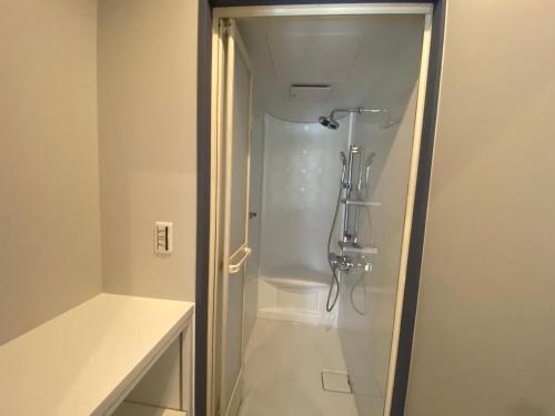 a shower stall in a bathroom with a toilet at ikibase Guest House in Iki
