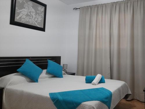 a bedroom with two beds with blue and white pillows at Apartamentos Carlota in Puerto del Carmen