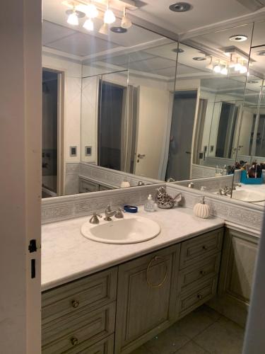 a bathroom with a sink and a large mirror at Tagle-Recoleta in Buenos Aires
