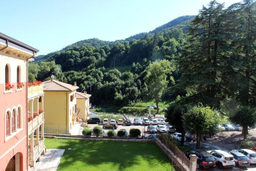 a group of cars parked in a parking lot with a mountain at Hotel Baldo in Ferraro di Monte Baldo