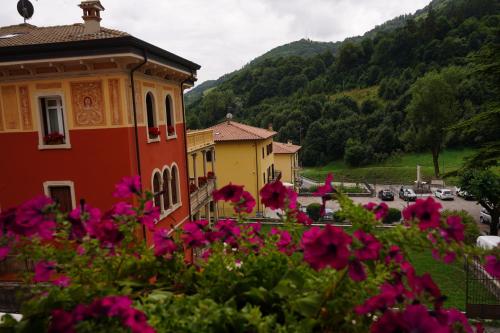 a group of buildings with pink flowers in the foreground at Hotel Baldo in Ferraro di Monte Baldo