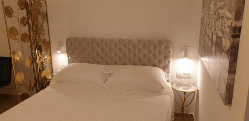 a white bed in a room with two lights at Golden Studio - private parking in Dubrovnik
