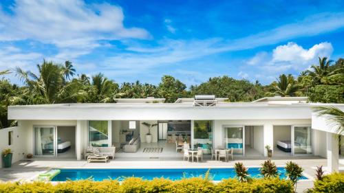 a villa with a swimming pool in front of it at Mama Taras Luxury Villa in Ngatangiia