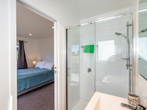 a bathroom with a shower and a bed at Family Retreat in Snowmass - Ohakune Holiday Home in Ohakune