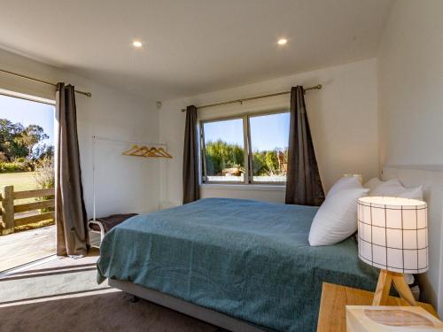 a bedroom with a bed and a large window at Family Retreat in Snowmass - Ohakune Holiday Home in Ohakune
