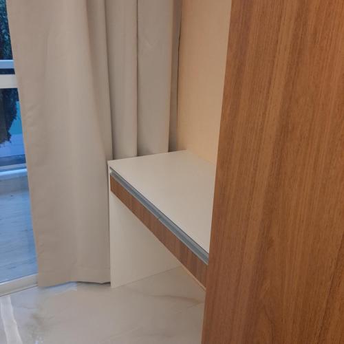 a room with a white shelf and a wooden door at Apartamento Mania in Vitória