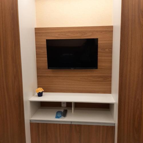 a flat screen tv sitting on a wall at Apartamento Mania in Vitória