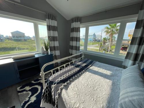 een slaapkamer met een bed en 2 ramen bij Dog Friendly Cottage just steps to beach / Outdoor living & dining room / Tons of Amenities / Book Now! in Gulf Shores