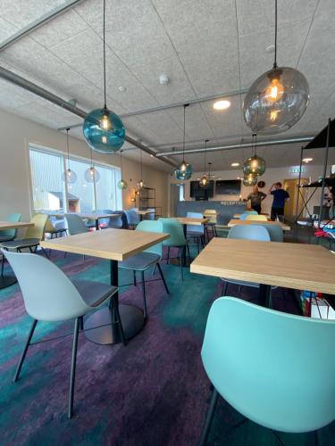 a restaurant with tables and chairs and people in the background at Hotel Aurora in Nuuk