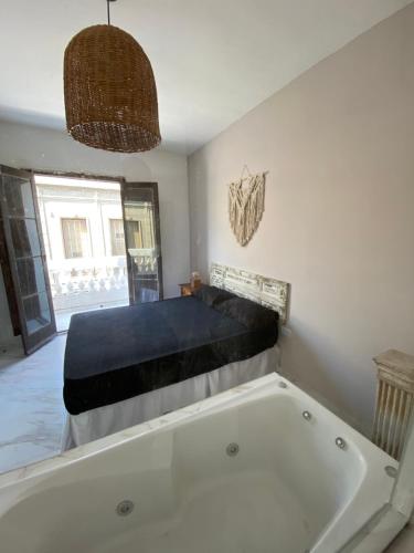 a bathroom with a bath tub and a bed at Bardot Hostel in Paraná