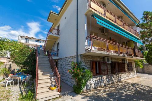 ein Gebäude mit einer Treppe, einem Balkon und einem Tisch in der Unterkunft Apartments Ana - private parking in Crikvenica