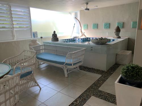 a room with a table and chairs and a tub at Beachside 4 with private heated plunge pool in Port Douglas